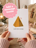 A person holds a white greeting card with a yellow tent illustration and the text 'YOU'RE TENT-SATIONAL' in a cozy indoor setting. A pink scalloped badge in the top left says 'Add a message inside'.